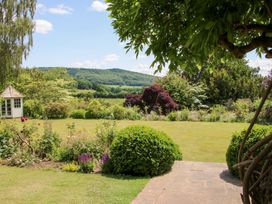 A garden with a gazebo and flowers at Uplands House Ledbury