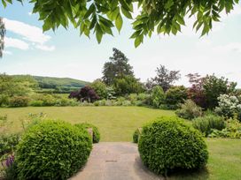 A garden with lawn and bushes at Uplands House in Ledbury