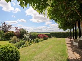 A garden with flowering plants and a pathway at Uplands House in Ledbury