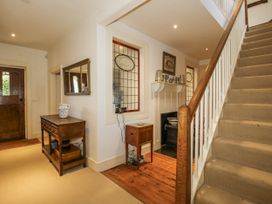 A hallway with a staircase and table at Uplands Dowerhouse Wellington Heath near Ledbury