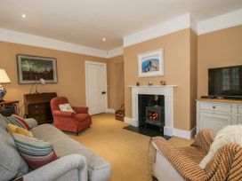 A living room with a fireplace and television at Uplands Dowerhouse Wellington Heath near Ledbury