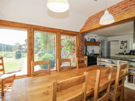 A dining room with a wooden table and chairs at Uplands Dowerhouse Wellington Heath near Ledbury