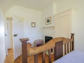 A bedroom with a bed and a chair at Uplands Dowerhouse Wellington Heath near Ledbury