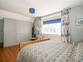 A bedroom with a bed and wardrobe at Uplands Dowerhouse in Wellington Heath near Ledbury