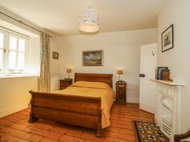 A bedroom with a bed and lamp at Uplands Dowerhouse Wellington Heath near Ledbury