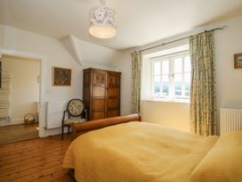 A bedroom with a bed and wardrobe at Uplands Dowerhouse in Wellington Heath near Ledbury