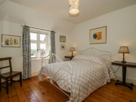 A bedroom with a bed, table, and chair at Uplands Dowerhouse in Wellington Heath near Ledbury