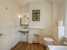 A bathroom with a sink, toilet, and a mirror at Uplands Dowerhouse Wellington Heath near Ledbury