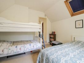A bedroom with a bunk bed and a single bed at Uplands Dowerhouse in Wellington Heath near Ledbury