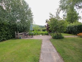 A garden area with a table and chairs near a pond at Uplands Cottage Ledbury