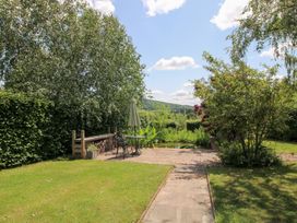 A garden with a table and chairs under an umbrella at Uplands Cottage in Ledbury