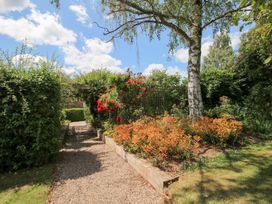 A garden with a pathway and flowers at Uplands Cottage in Ledbury