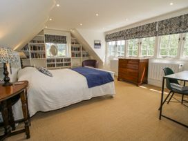 A bedroom with a bed and bookshelf at Garden Cottage in Wellington Heath near Ledbury