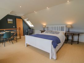 A bedroom with a bed and desk at Garden Cottage in Wellington Heath near Ledbury
