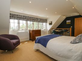A bedroom with a bed and a chair at Garden Cottage in Wellington Heath near Ledbury