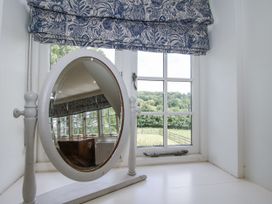 A mirror and window with outdoor view at Garden Cottage in Wellington Heath near Ledbury