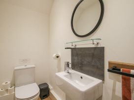 A bathroom with a sink, toilet, and mirror at Garden Cottage near Wellington Heath