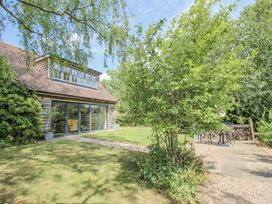 A garden with a building and trees at Garden Cottage in Wellington Heath near Ledbury