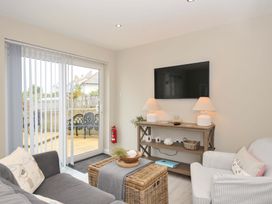 A living room with a television and seating at Evelyn in Looe