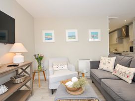 A living room with a sofa and armchair at Evelyn in Looe