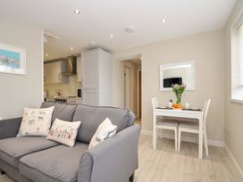 A living room with a sofa and dining table at Evelyn in Looe