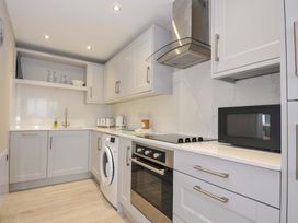 A kitchen with appliances and cabinets at Evelyn in Looe