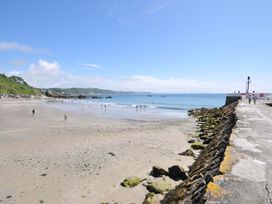A beach with people and water at Evelyn in Looe