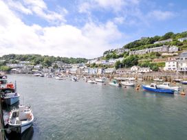 A harbor with boats moored and houses on the shore at Evelyn in Looe