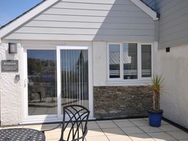 An outdoor area with sliding door and windows at Evelyn in Looe