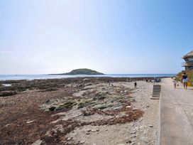 A beach with rocks and people at Evelyn in Looe