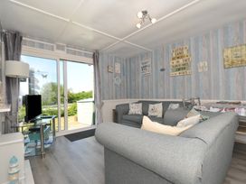 A living room with a sofa and television at 13 Hillside, Bude
