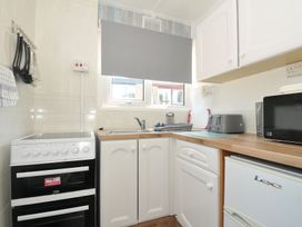 A kitchen with an oven, sink, and appliances at 13 Hillside in Bude