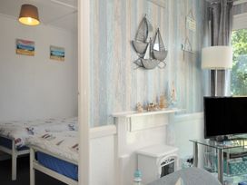 A living room with a bed and decorative items at 13 Hillside in Bude