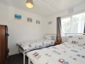 A bedroom with two beds and a wardrobe at 13 Hillside in Bude