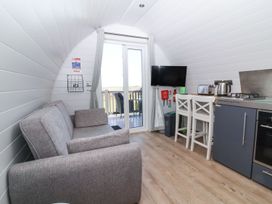 A living room with a sofa and TV at New Pod in Kilkhampton