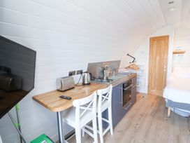 A kitchen area with appliances and seating at New Pod in Kilkhampton