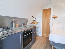 A kitchen with bed and cooking area at New Pod in Kilkhampton