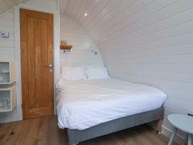 A bedroom with a bed and shelf at New Pod in Kilkhampton