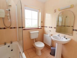 A bathroom with a shower, bathtub, toilet, and sink at 51 Woodview Park, Tralee, County Kerry