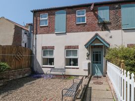 An outdoor area with a bench and gravel at 4 Londesborough Mews