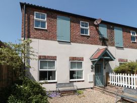A house exterior with windows, a door, and garden furniture at 4 Londesborough Mews