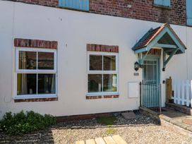 An exterior view of a house with windows and a door at Farriers Cottage in Bridlington