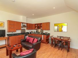 A kitchen with wooden cabinets and dining area at Farriers Cottage in Bridlington