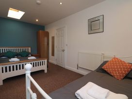 A bedroom with two beds and a wardrobe at Farriers Cottage in Bridlington