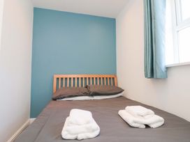 A bedroom with a bed and towels arranged at Farriers Cottage in Bridlington