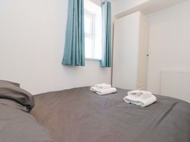 A bedroom with a bed and towels at Farriers Cottage in Bridlington