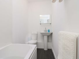 A bathroom with a bathtub, toilet, and sink at Farriers Cottage in Bridlington