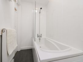 A bathroom with a bathtub and a showerhead at Farriers Cottage in Bridlington