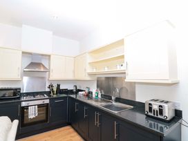 A kitchen with cabinets, sink, stove, and toaster at Chestnut Cottage in Bridlington