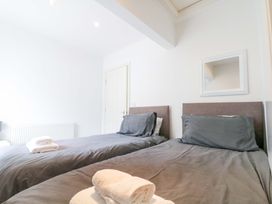 A bedroom with two beds and towels on the beds at Chestnut Cottage in Bridlington